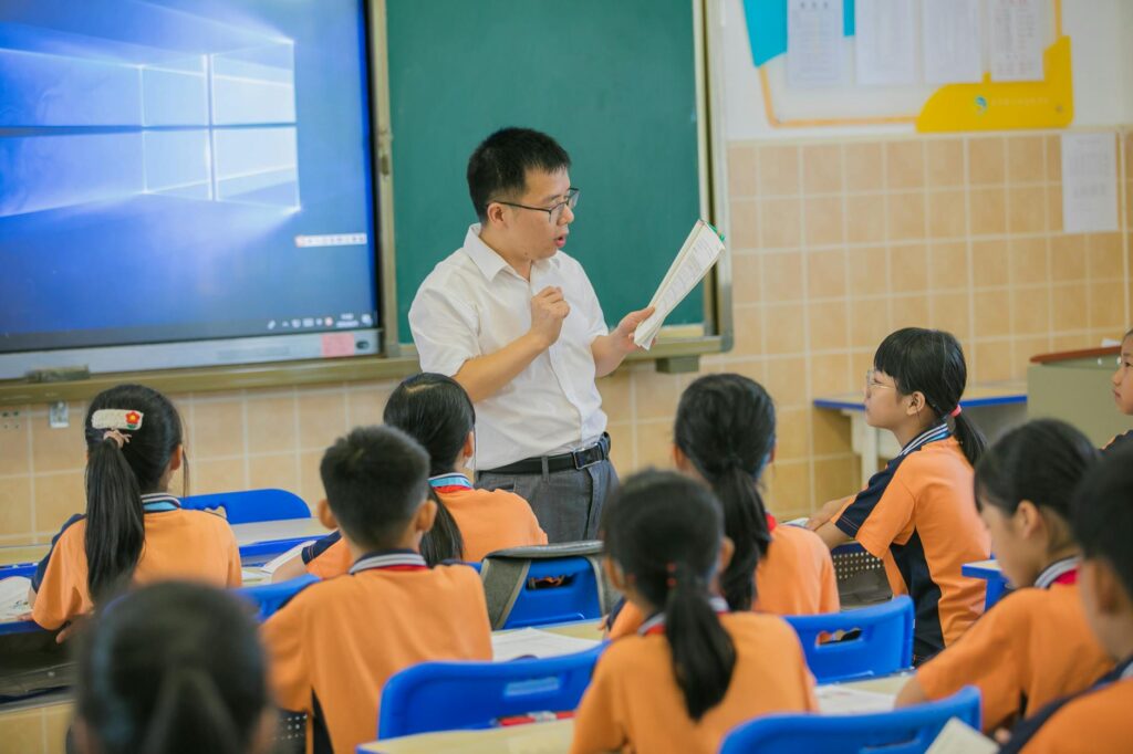 Teacher instructing attentive students in a classroom setting, fostering education and learning.