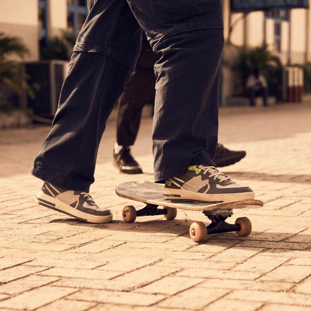 A skateboarder wearing sneakers skateboarding on a sunny day outdoors.