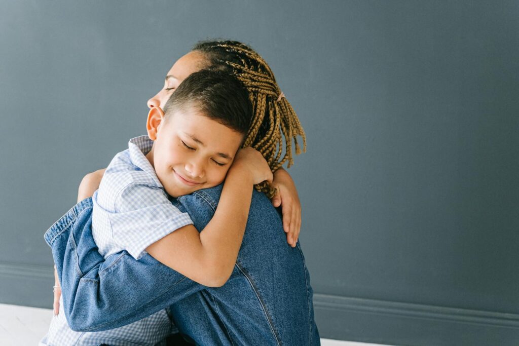 A mother and son share a loving embrace, radiating joy and connection.