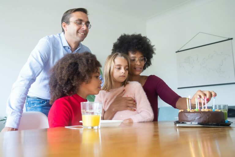 Happy family celebrating a child's birthday with cake and candles.