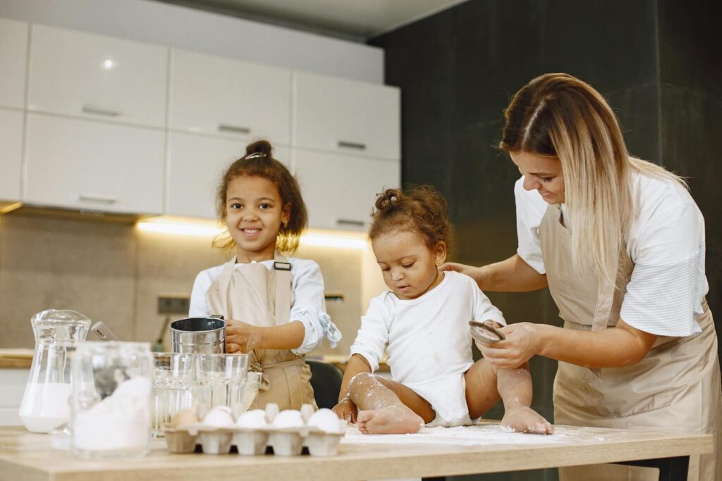 A mother and her children enjoying a fun baking session in the kitchen.