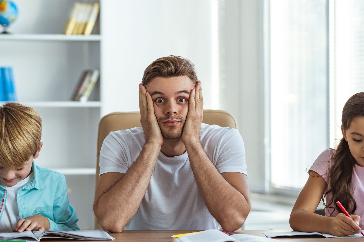 dad looking frustrated while helping kids with homework