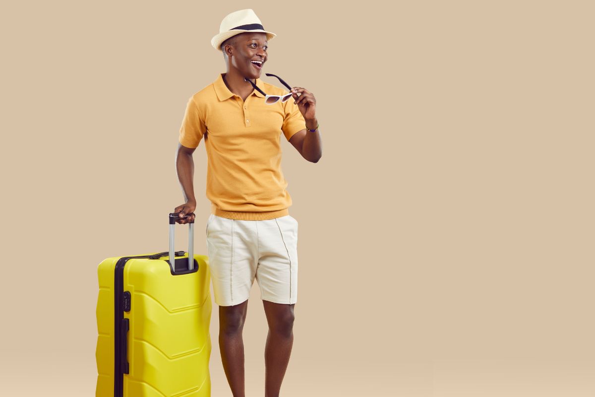 man dressed for vacation with a suitcase