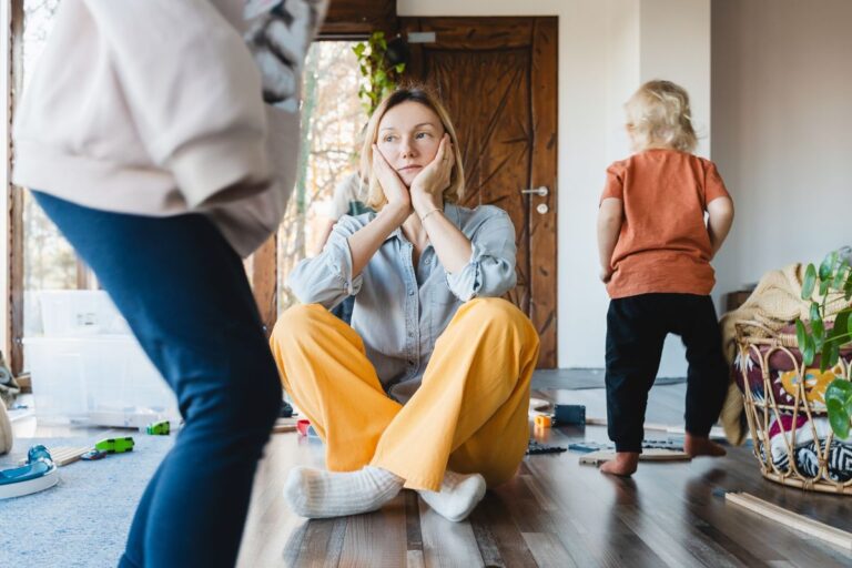 sad mom with kids playing