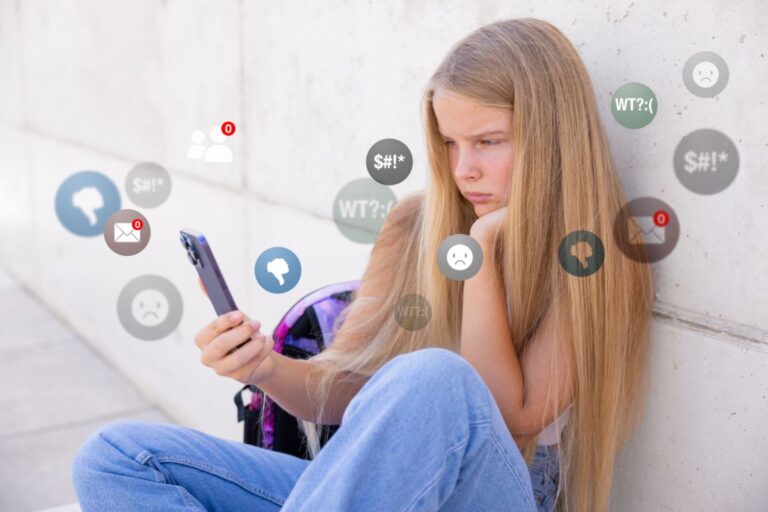 girl sitting upset at her phone, social media bubbles around her