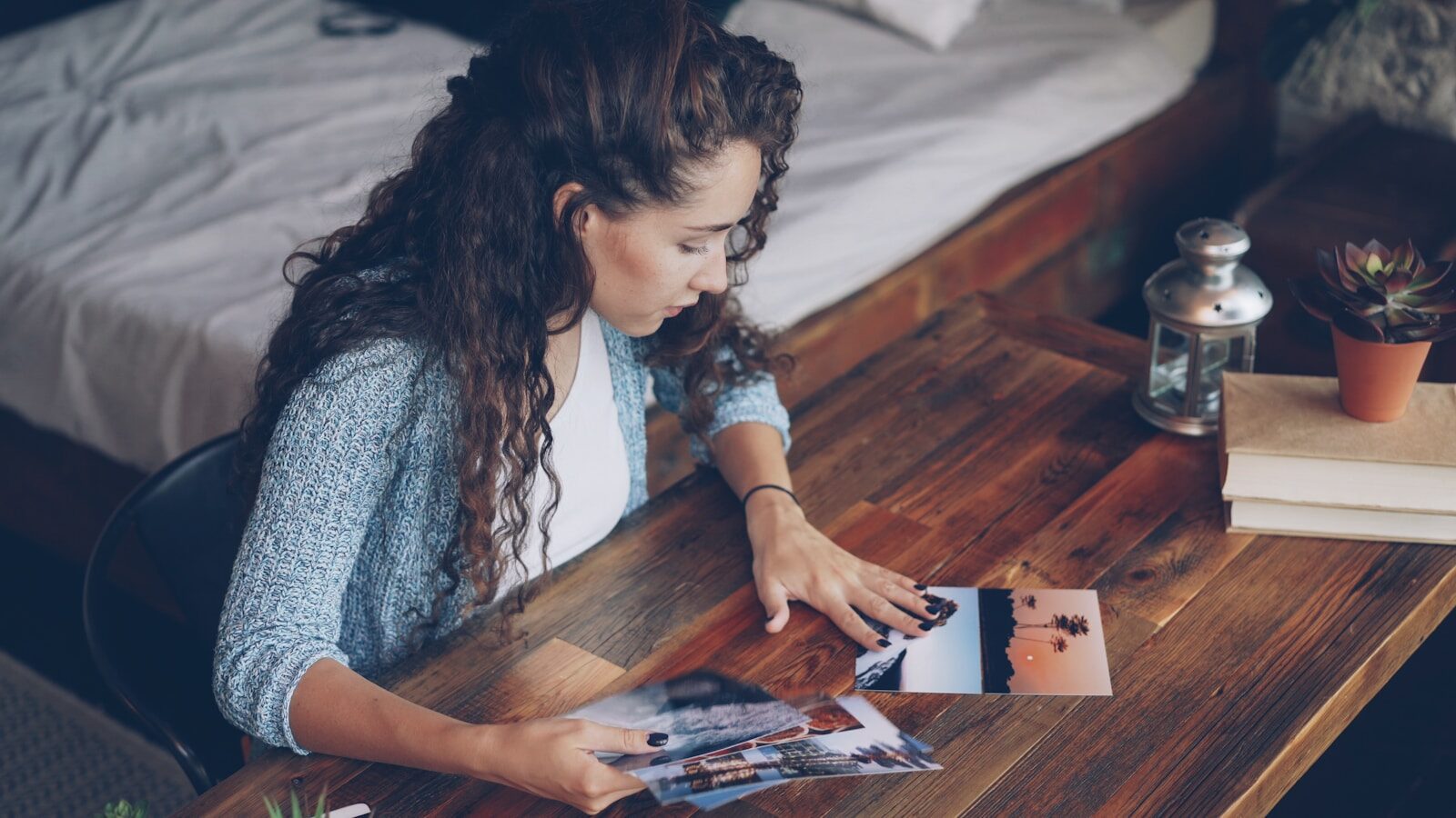 Woman looking at photographs on a wooden table
