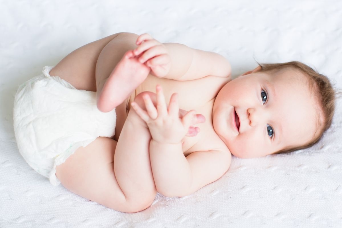 Baby holding his legs in a diaper