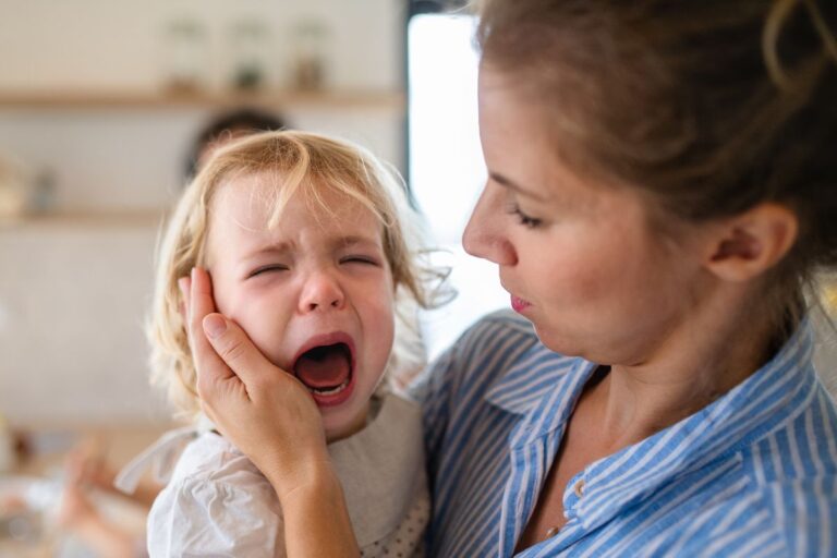Child crying while mom holds her