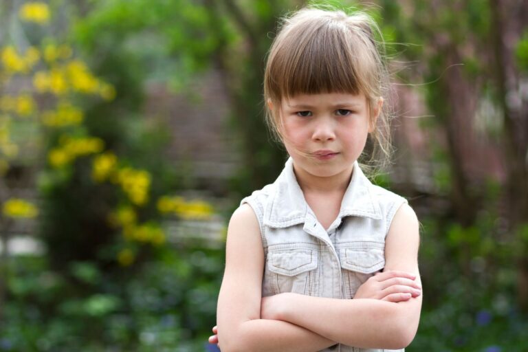 Little girl crossing her arms, with bangs