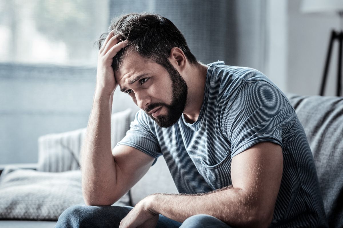 Man looking depressed sitting on a couch