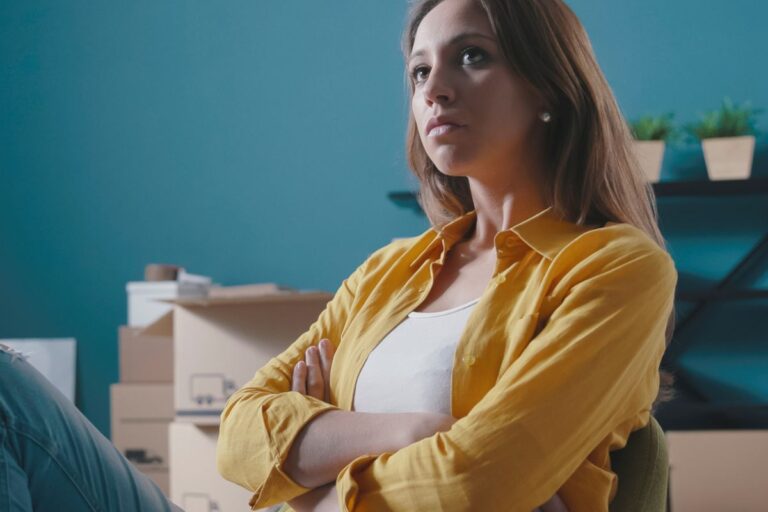 Woman upset crossing her arms with boxes around her