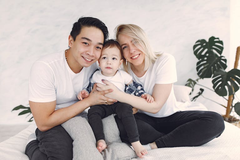 A joyful family moment captured as a couple with their child indoors, smiling and together.