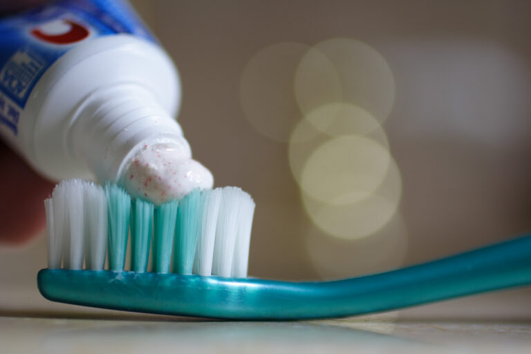 A strip of toothpaste squeezed onto the bristles of a toothbrush