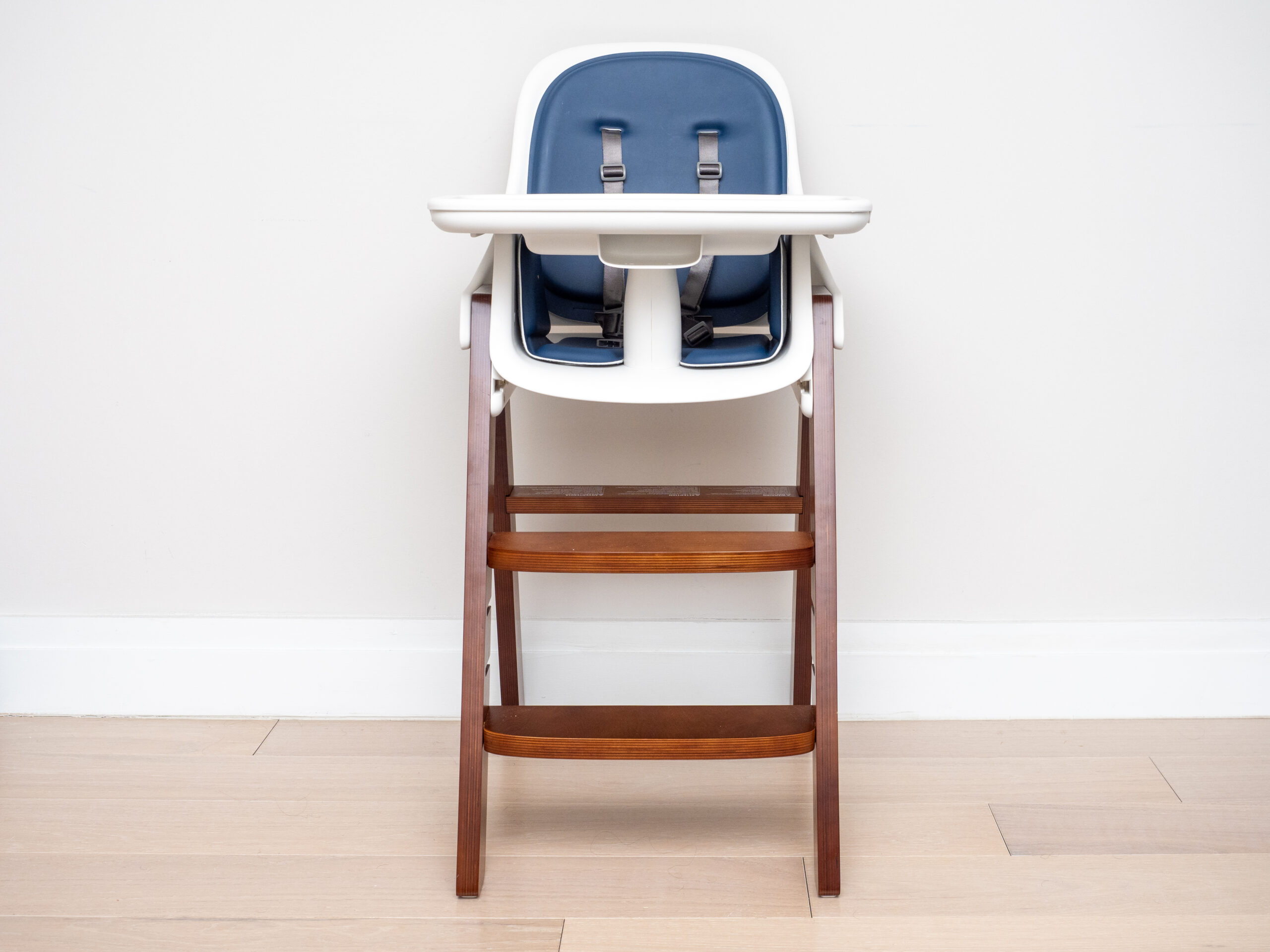 A child's high chair with a tray standing in a home