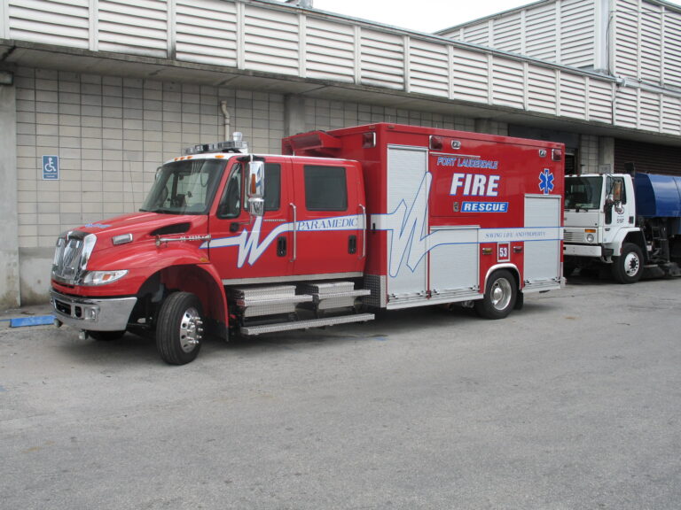 A red and white Florida fire rescue truck parked outside a station