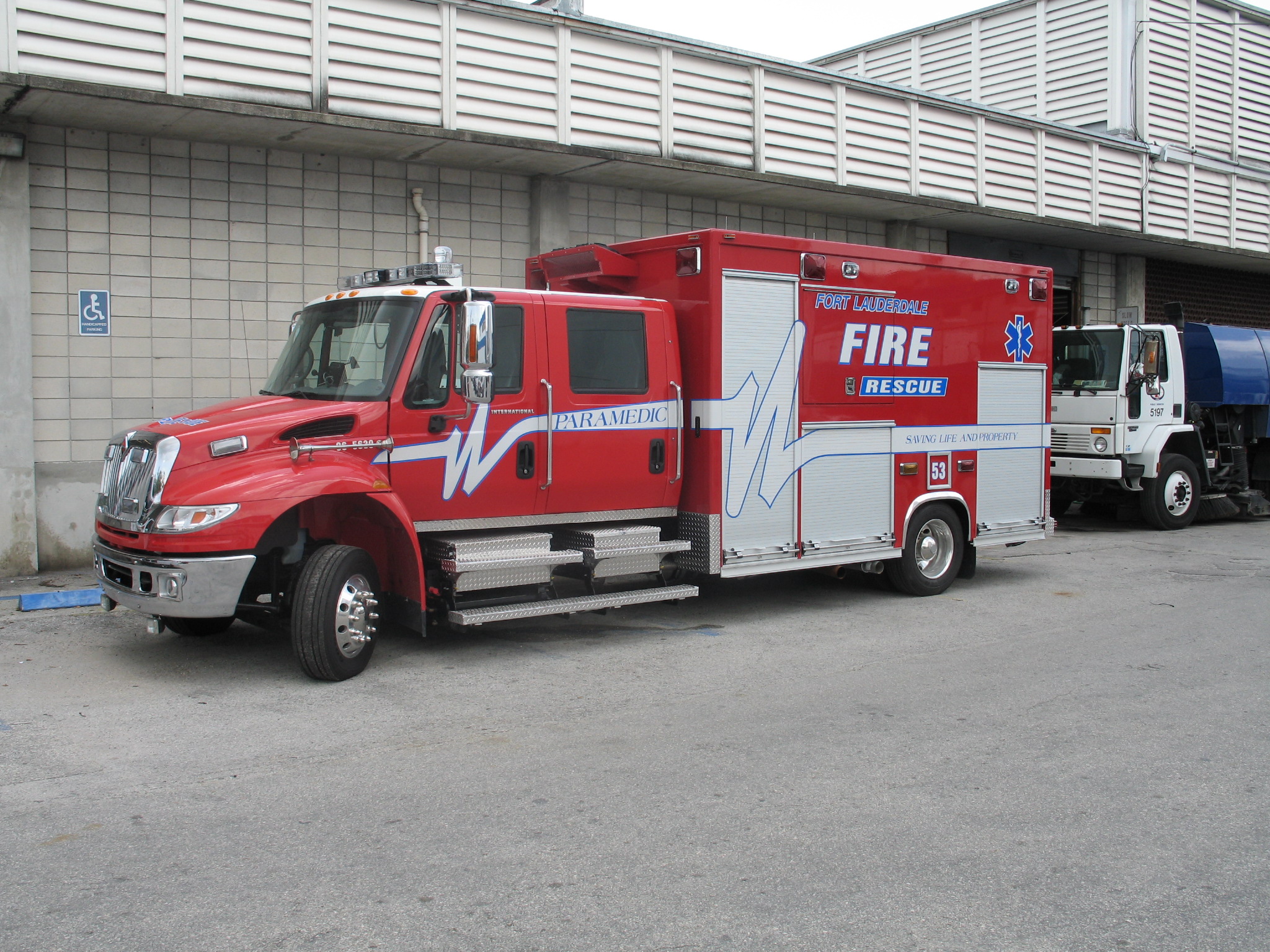 A red and white Florida fire rescue truck parked outside a station