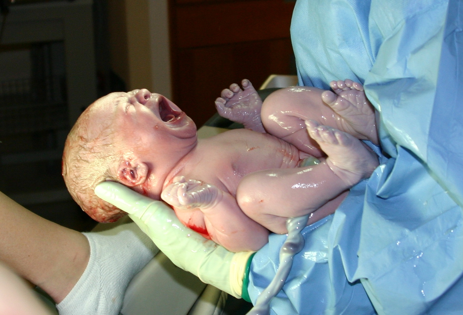 A newborn baby lying swaddled in a hospital blanket