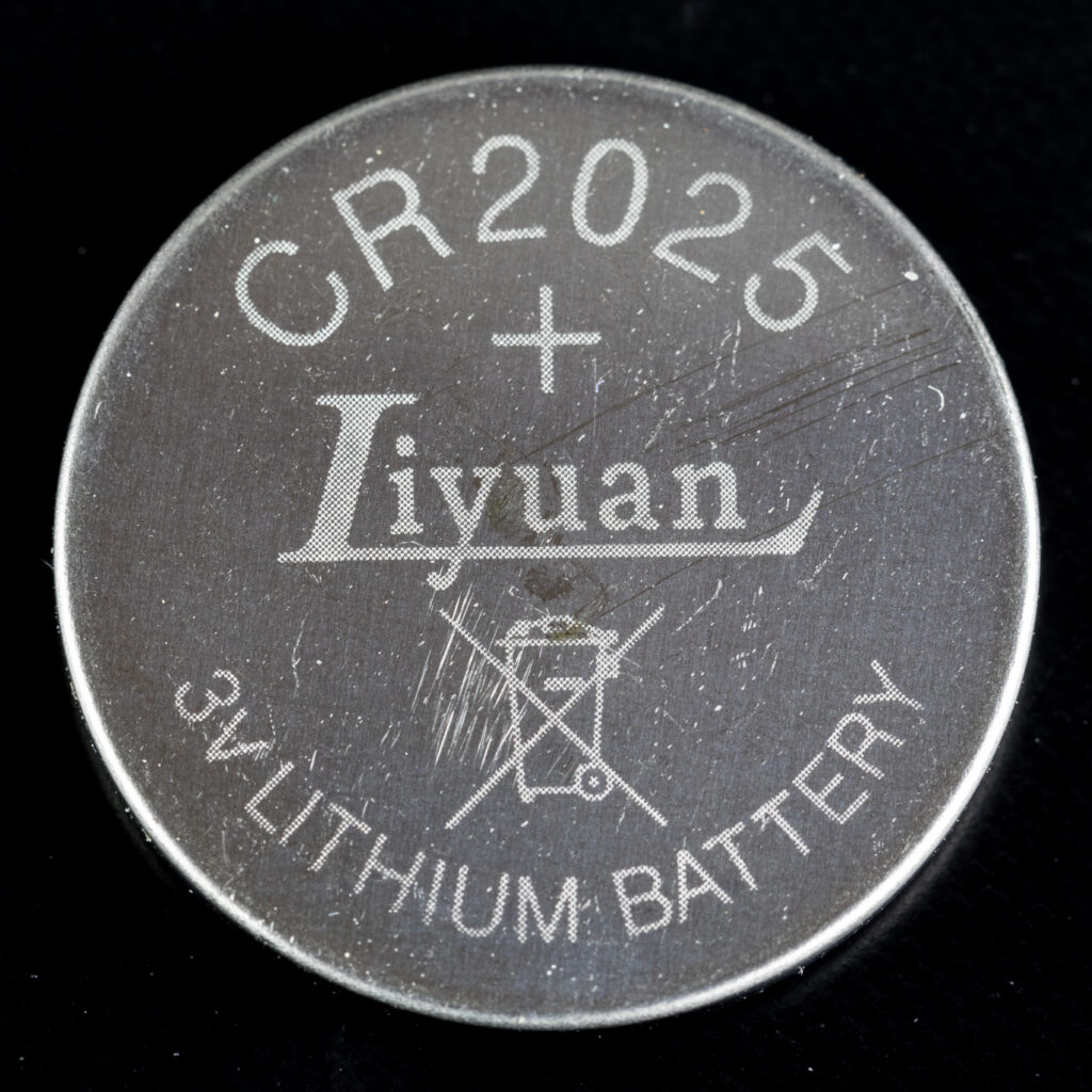 Close-up of a small round lithium coin cell battery