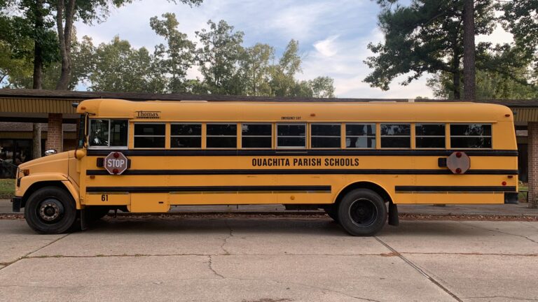 A yellow school bus parked outside an elementary school